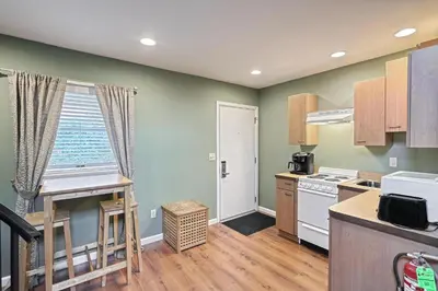 a kitchen with green walls and a table and a window at Suites On Chocolate - The Zoo in Hershey