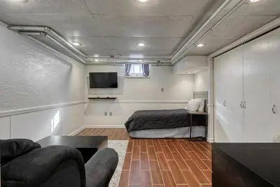 a room with a bed and a tv and a couch at Suites On Chocolate - The Studio in Hershey