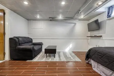 a bedroom with a bed and a chair and a tv at Suites On Chocolate - The Studio in Hershey