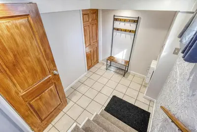 a hallway with a wooden door and a tile floor at Suites On Chocolate - The Studio in Hershey