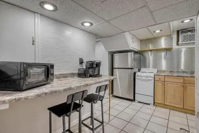 a kitchen with a counter with stools and a microwave at Suites On Chocolate - The Studio in Hershey