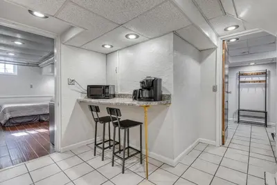 a kitchen with a counter with stools and a microwave at Suites On Chocolate - The Studio in Hershey
