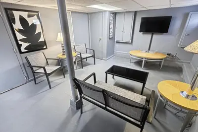 a waiting room with chairs and tables and a tv at Suites On Chocolate - The Annville Cottage in Annville