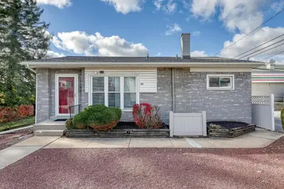 a small white house with a porch at Suites On Chocolate - The Annville Cottage in Annville