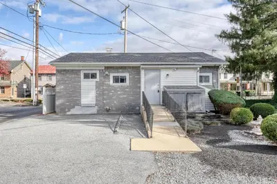 a gray brick house with a garage at Suites On Chocolate - The Annville Cottage in Annville