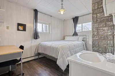 a bedroom with a bed and a sink and a tub at Suites On Chocolate - The Annville Cottage in Annville