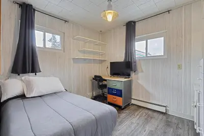 a bedroom with a bed and a desk with a computer at Suites On Chocolate - The Annville Cottage in Annville