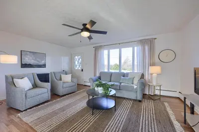 a living room with two couches and a ceiling fan at Mountain Sunrise Retreat in Klingerstown