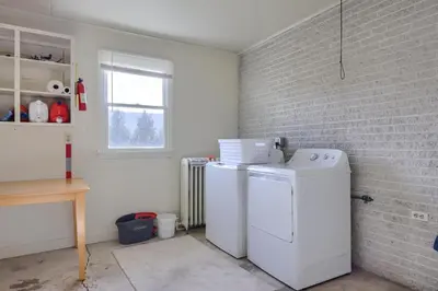 a laundry room with two refrigerators and a brick wall at Mountain Sunrise Retreat in Klingerstown