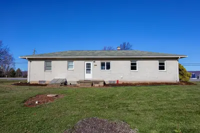 a white house with a bench in a yard at Mountain Sunrise Retreat in Klingerstown
