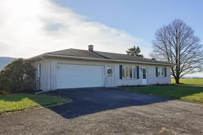 a white house with a garage at Mountain Sunrise Retreat in Klingerstown