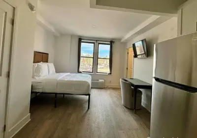 a small room with a bed and a refrigerator at Close to Times Square! Stunning Studio in NYC! in New York