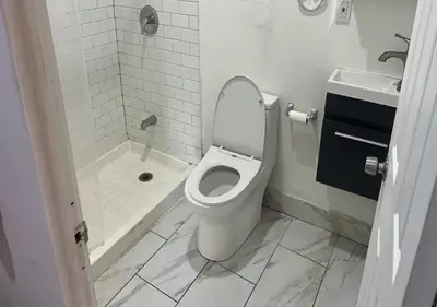 a white bathroom with a toilet and a shower at Close to Times Square! Stunning Studio in NYC! in New York