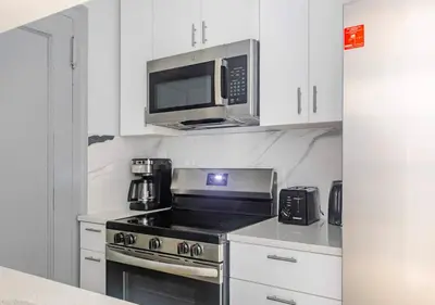 a kitchen with a stove and a microwave at Midtown West 2 Bedroom Furnished Apartment Rental in New York