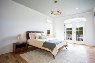 a white bedroom with a bed and a chandelier at Lakeview Villa with Private Hot Tub, Firepit & Breathtaking Cliff Views in Greenwood Lake
