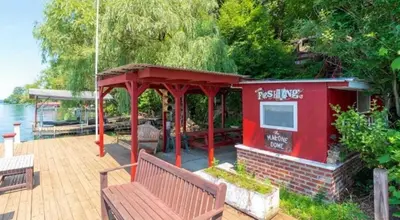 a deck with a gazebo and two benches at Cayuga lake cottage with private lake access in Washingtonville