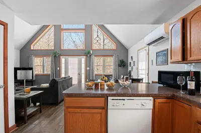 a kitchen with a counter and a living room at Hot Tub Fire-place Game Room Arrowhead Lake in Thornhurst