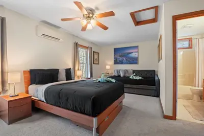 a bedroom with a bed and a couch and a ceiling fan at Hot Tub Fire-place Game Room Arrowhead Lake in Thornhurst