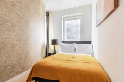 a bedroom with a bed with a yellow blanket at Blueground Midtown S gym roof nr Times Sq NYC-1776 in New York