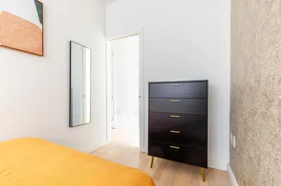 a bedroom with a black dresser and two mirrors at Blueground Midtown S gym roof nr Times Sq NYC-1776 in New York