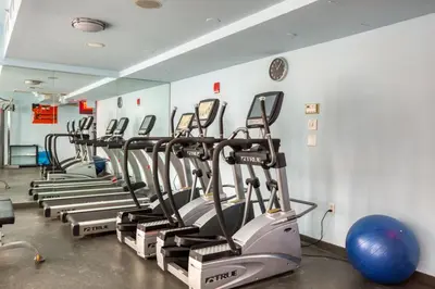 a row of exercise bikes lined up in a gym at Blueground Midtown S gym roof nr Times Sq NYC-1776 in New York