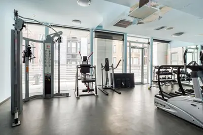 a gym with treadmills and elliptical machines at Blueground Midtown S gym roof nr Times Sq NYC-1776 in New York