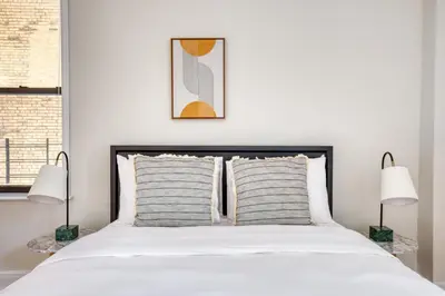 a bedroom with a large white bed with two lamps at UWS 2br w wd doorman gym nr Central Park NYC-1082 in New York