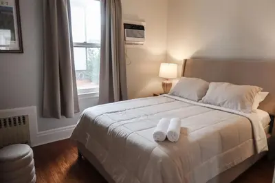 a bedroom with a bed with two towels on it at Cozy 2BR 5min to NYC Train and 10min to Seton Hall in West Orange