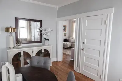 a living room with a table and a mirror at Cozy 2BR 5min to NYC Train and 10min to Seton Hall in West Orange