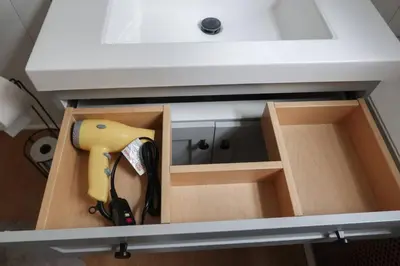 a bathroom sink with a drill in a drawer under it at Cozy 2BR 5min to NYC Train and 10min to Seton Hall in West Orange