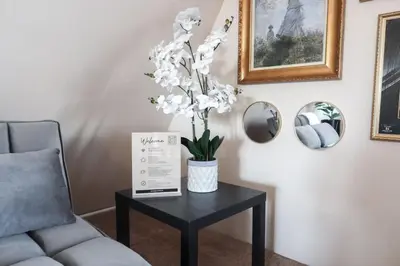 a table with a vase of white flowers on it at Cozy Attic Studio for 2 5min to NYC Train Station in West Orange