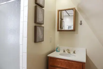 a bathroom with a sink and a mirror at Cozy Attic Studio for 2 5min to NYC Train Station in West Orange
