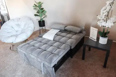 a bed and a ottoman in a room at Cozy Attic Studio for 2 5min to NYC Train Station in West Orange
