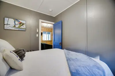 a bedroom with a bed and a blue door at Lakeside Haven, a Modern Cottage with Lake Views in Effort