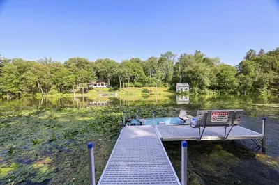 a dock with a bench next to a lake at Lakeside Haven, a Modern Cottage with Lake Views in Effort