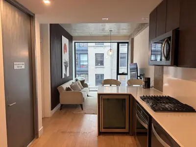 a kitchen with a counter top and a living room at Best Location in Greenwich Village in New York
