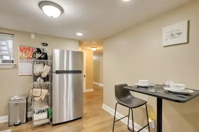 a kitchen with a stainless steel refrigerator and a table at 1 Mi to Dtwn Wilmington Convenient and Cozy Home! in Wilmington