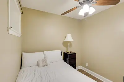 a bedroom with a bed with a ceiling fan at 1 Mi to Dtwn Wilmington Convenient and Cozy Home! in Wilmington