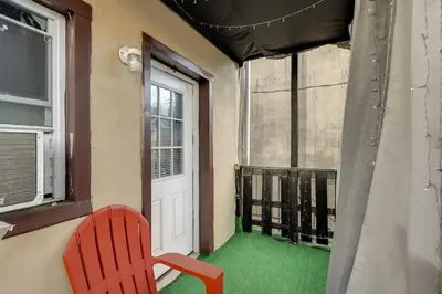 a red chair sitting in front of a window at 1 Mi to Dtwn Wilmington Convenient and Cozy Home! in Wilmington