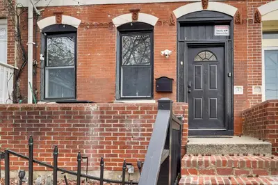 a brick house with a black door and two windows at 1 Mi to Dtwn Wilmington Convenient and Cozy Home! in Wilmington