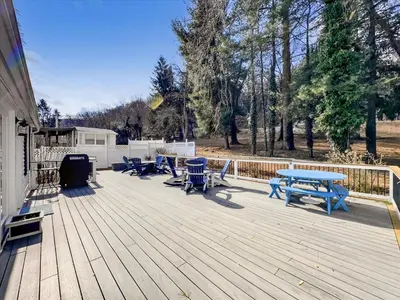 a deck with picnic tables and chairs on it at The White House by Leavetown Vacations in Wrightsville