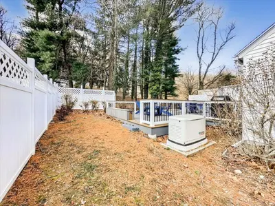 a white fence in a yard next to a house at The White House by Leavetown Vacations in Wrightsville