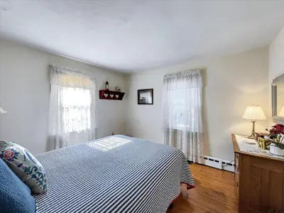 a bedroom with a bed and two windows at The White House by Leavetown Vacations in Wrightsville