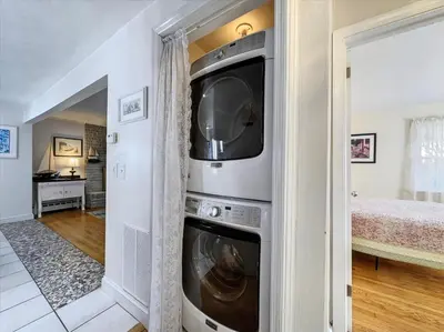 a living room with a washer and dryer in a house at The White House by Leavetown Vacations in Wrightsville