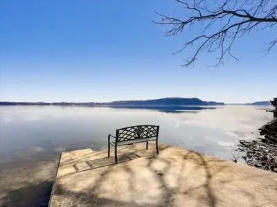 a bench sitting on the edge of a body of water at The White House by Leavetown Vacations in Wrightsville