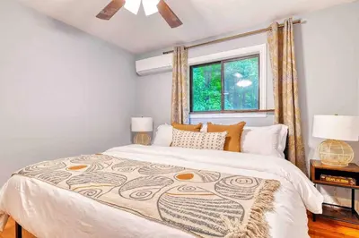 a bedroom with a large bed and a window at Grand Woodland Retreat - Hot Tub - Game Room in Gouldsboro