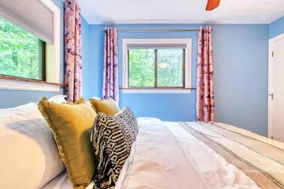 a bedroom with blue walls and a bed with pillows at Grand Woodland Retreat - Hot Tub - Game Room in Gouldsboro