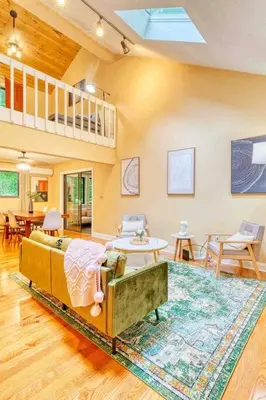 a living room with a couch and a rug at Grand Woodland Retreat - Hot Tub - Game Room in Gouldsboro
