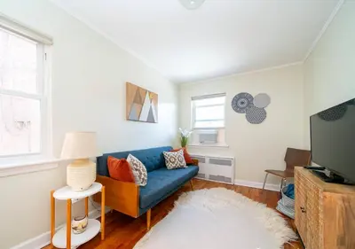 a living room with a blue couch and a tv at Midtown West 3 Bedroom Washer dryer and Dishwasher, June to Aug 90 days stay required in New York