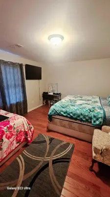 a bedroom with two beds and a flat screen tv at Divine Villa and Resort - 32 Evergreen in Newark